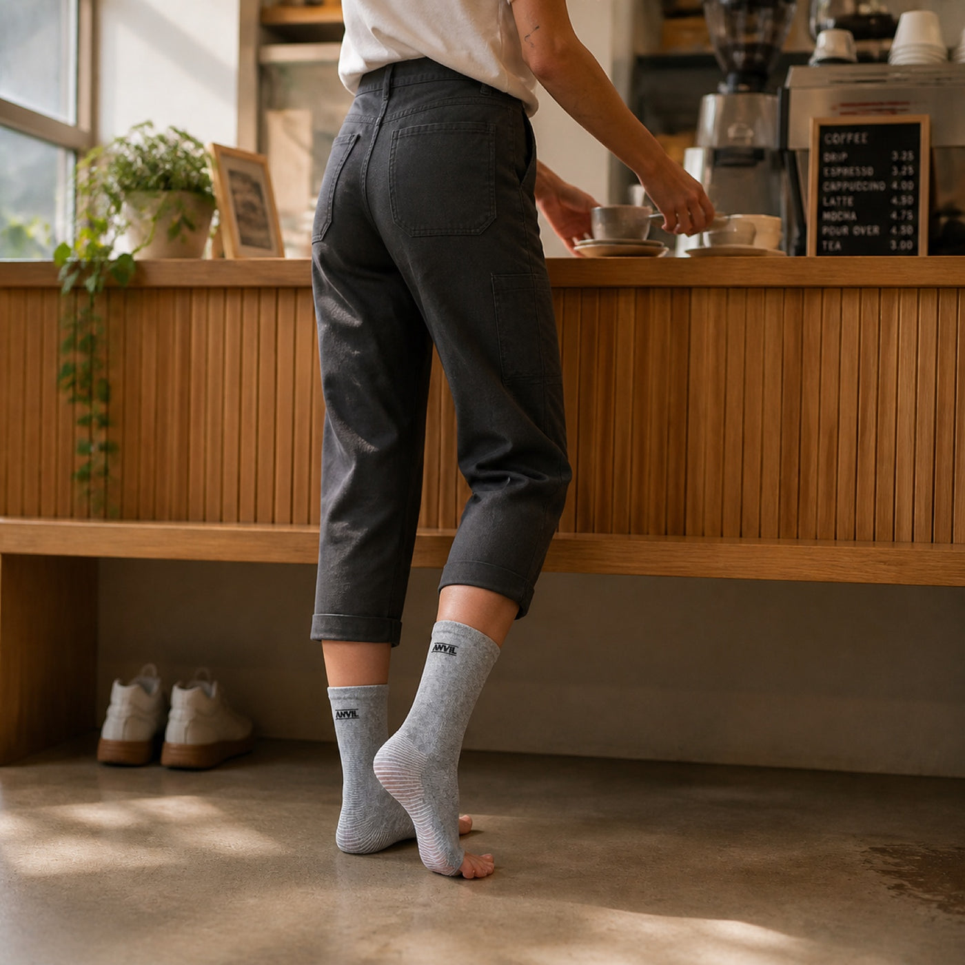 Person working at a cafe table in gray toeless ANVIL foot sleeves.