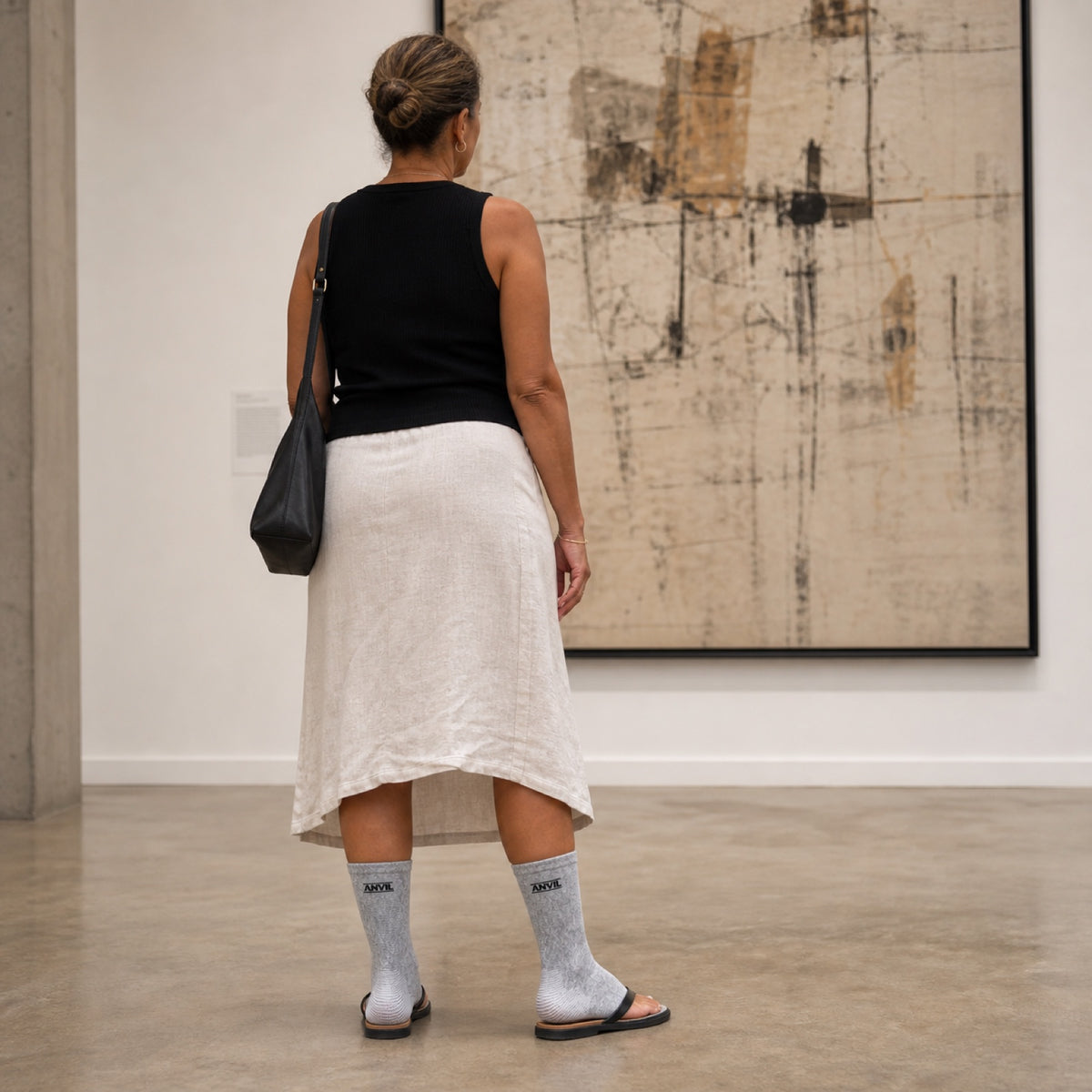 Person in a museum gallery in gray toeless ANVIL foot sleeves.