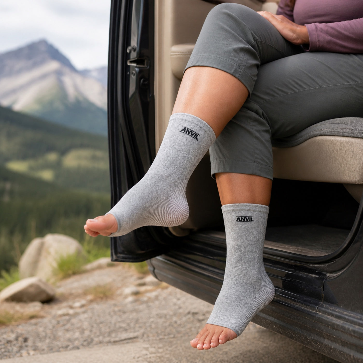 Person resting their feet in a parked vehicle in gray toeless ANVIL foot sleeves.