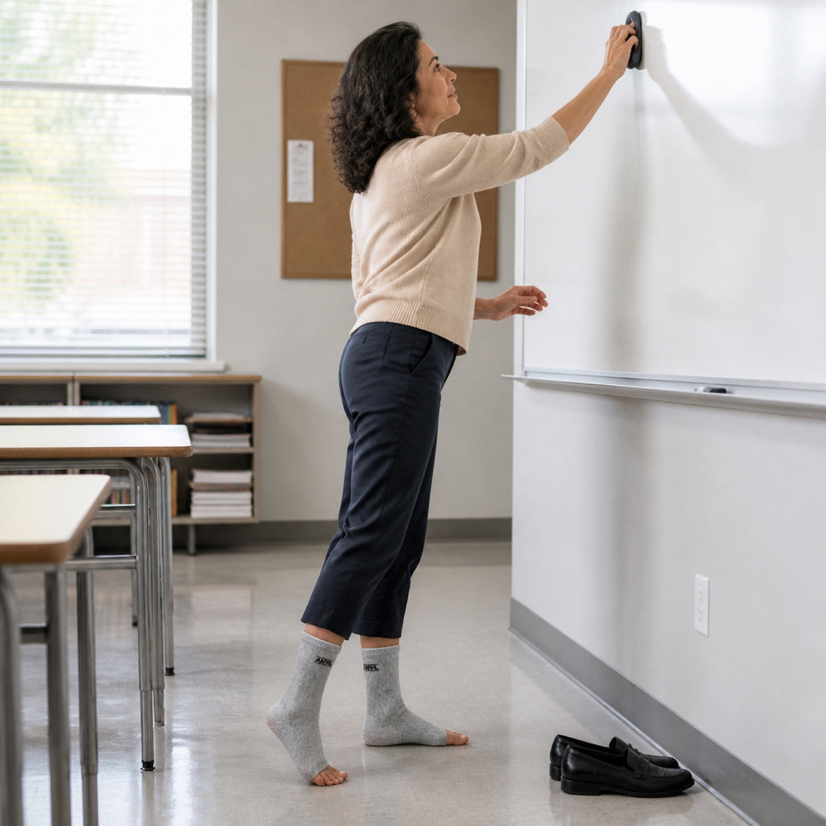Person in a classroom in gray toeless ANVIL foot sleeves.