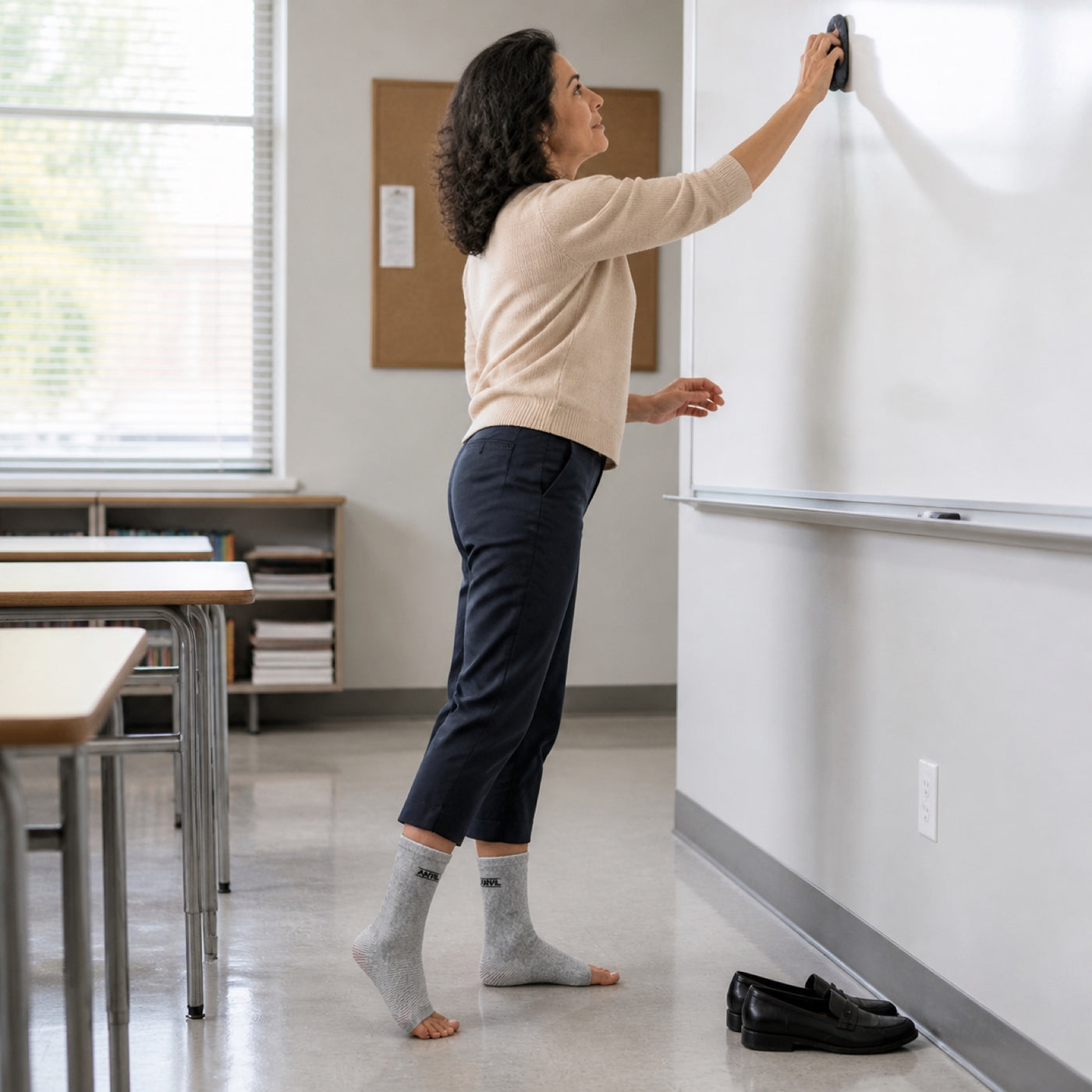 Person in a classroom in gray toeless ANVIL foot sleeves.