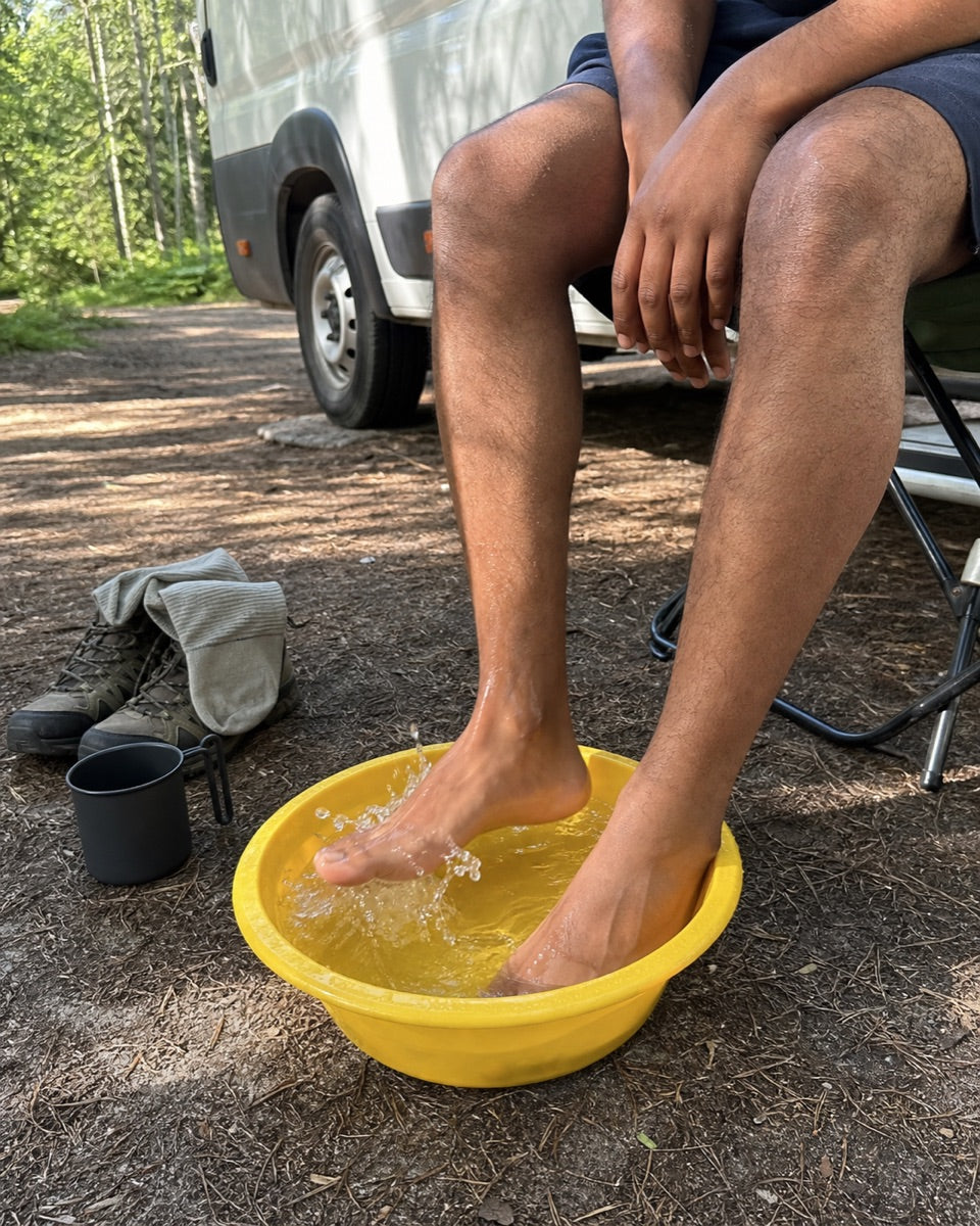 Feet soaking in a basin &mdash; campsite beside the van